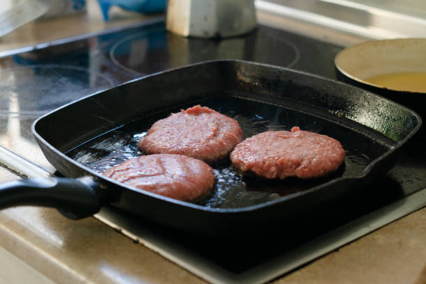 grill with three meat burgers prepared in domestic kitchen food picture