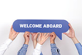 Group of people holding the WELCOME ABOARD written speech bubble