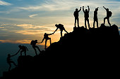 Group of people on peak mountain climbing helping team work , travel trekking success business concept