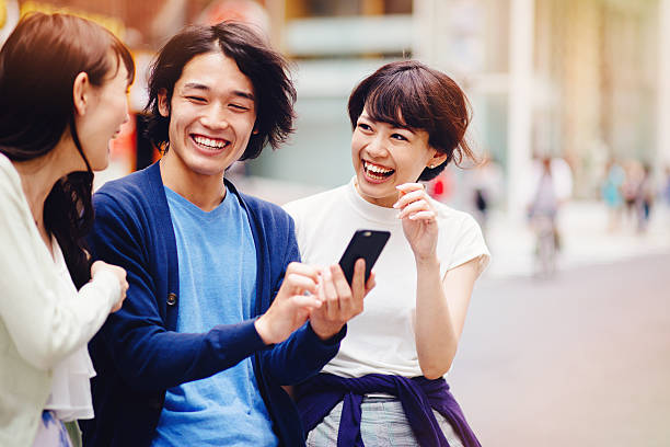 group of young japanese people with smart phone - asian woman talking about cellphone stock pictures, royalty-free photos & images