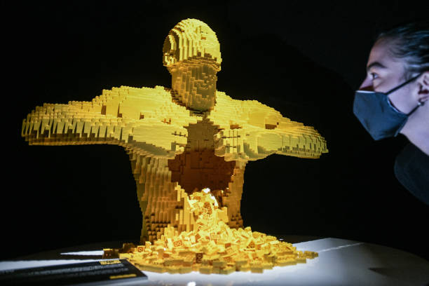 Guest looks at an artwork made with LEGO entitled 'Yellow' during 'The Art of the Brick' exhibition by Nathan Sawaya at Ride Milano Urban Hub in...