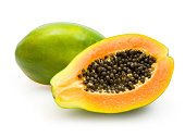Half papaya showing orange flesh and dark seeds green skin