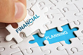 Hand holding piece of puzzle with words Financial Planning.