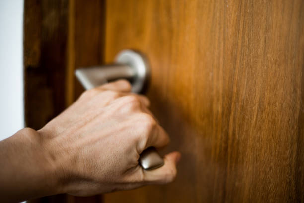 a hand holding the doorknob, opening / closing a door - door closed stock pictures, royalty-free photos & images