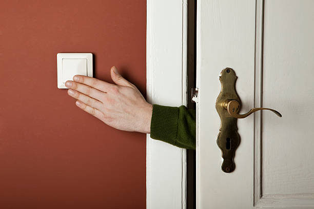 a hand turning off a light switch - interruptor - fotografias e filmes do acervo