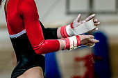 hands of girl in gymnast grips before performing on horizontal bar