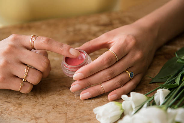 hands of hispanic woman holding jar of lip gloss - lip balm stock pictures, royalty-free photos & images