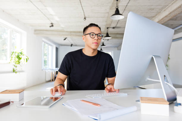 handsome asian man working in the creative workplace - black developer stock pictures, royalty-free photos & images