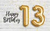 Happy 13th birthday gold foil balloon greeting white wall background.