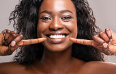 Happy black woman pointing at her perfect white teeth