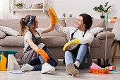 Happy Couple Giving High Five To Each Other After Cleaning Apartment