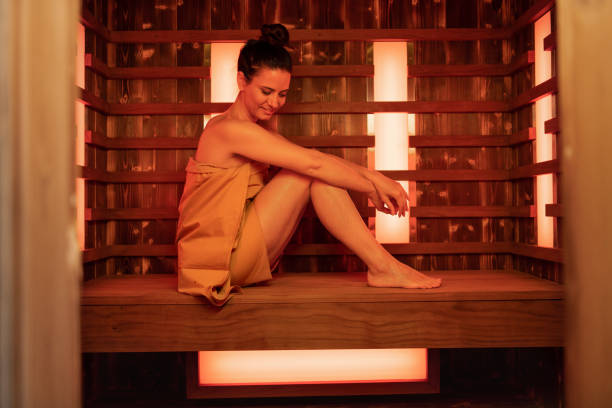 happy mid adult woman in red light therapy sauna