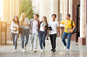 Happy students walking together in campus, having break