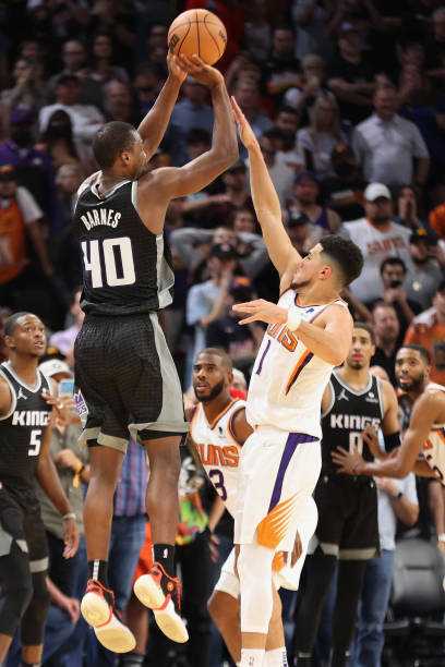 Harrison Barnes of the Sacramento Kings puts up the game-winning three-point shot over Devin Booker of the Phoenix Suns during the final seconds of...