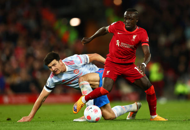 Harry Maguire of Manchester United looks on as Sadio Mane of Liverpool runs with the ball during the Premier League match between Liverpool and...