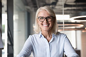 Headshot of middle-aged businesswoman posing at workplace