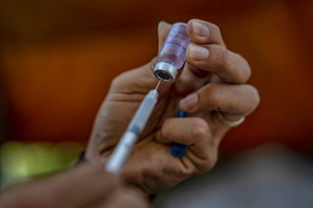 Healthcare worker prepares a dose of Sinovac CoronaVac COVID-19 vaccine at a rural village on December 01, 2021 in Aringay, La Union province,...