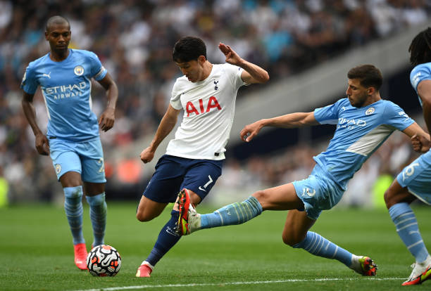 Heung-Min Son of Tottenham Hotspur fires in a shot as Ruben Dias of Manchester City challenges during the Premier League match between Tottenham...