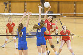 High school female volleyball player spiking the ball