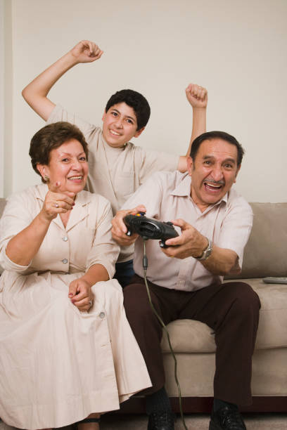 Hispanic grandparents and grandson playing video games