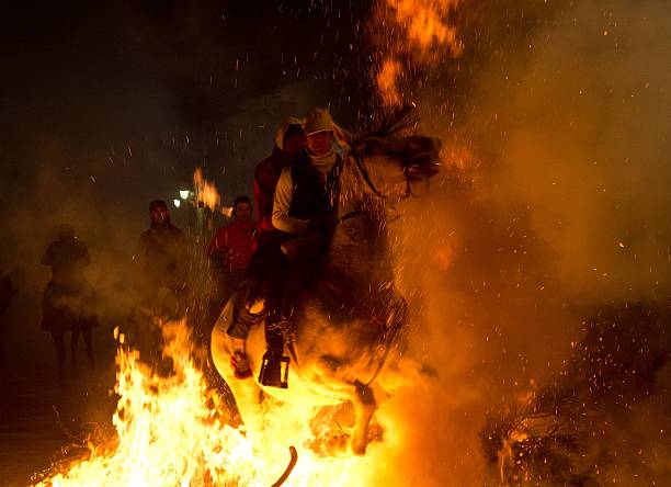 Horsemen jump over a bonfire in the Spanish central village of San Bartolome de Pinares in the province of Avila Castile and Leon during the opening...