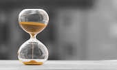 Hourglass on a black white blurred background. Time is money.