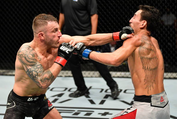 In this handout image provided by UFC, Alexander Volkanovski of Australia punches Max Holloway in their UFC featherweight championship fight during...