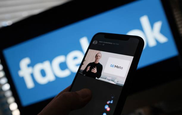 In this illustration photo taken in Los Angeles on October 28 a person watches on a smartphone Facebook CEO Mark Zuckerberg unveil the META logo. -...
