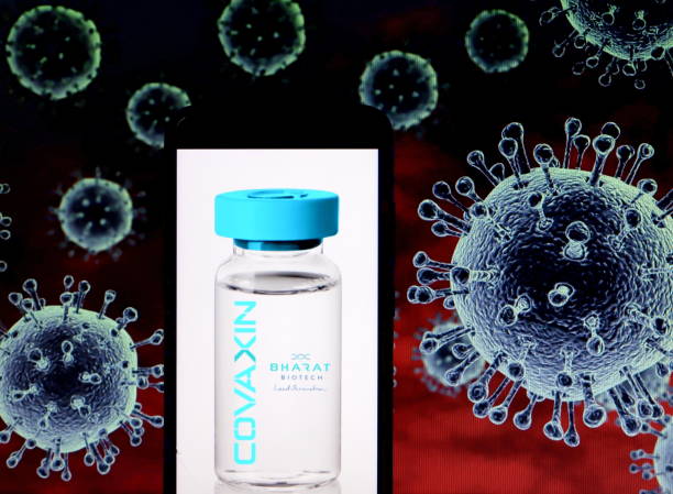In this Photo illustration a logo of Covaxin seen displayed on a smartphone with a COVID-19 coronavirus image in the background. Indian company...