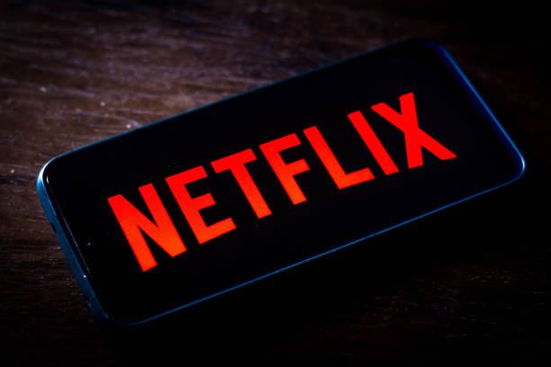 In this photo illustration the Netflix logo seen displayed on a smartphone screen. It is a global provider of movies and television series via...