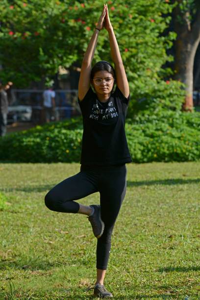 In this photograph taken on June 4, 2021 a girl performs Yoga ahead of the International Yoga day in a public park in Mumbai.