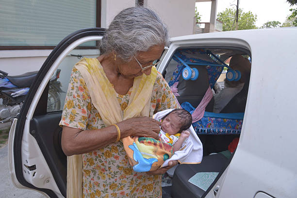 Indian mother Daljinder Kaur poses for a photograph as she holds her newborn baby boy Arman as she arrives home in Amritsar on May 11 2016 An Indian.. Punjabi Songs Online Listen and Download Videos, Images