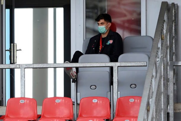 Injured Leverkusen's German midfielder Kai Havertz wearing a face mask sits in grandstand as he attends the German first division Bundesliga football...