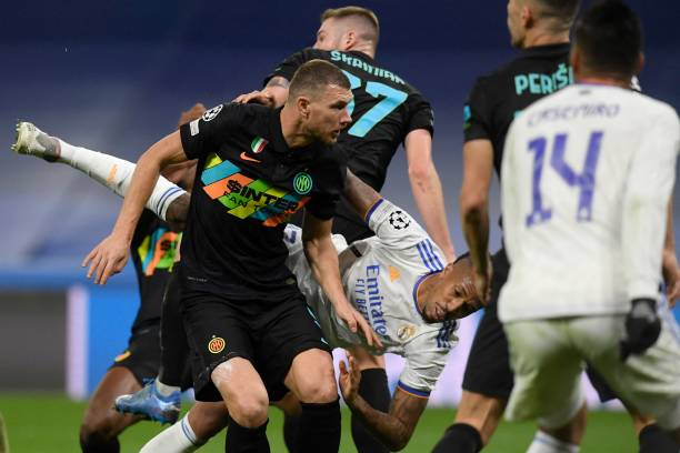 Inter Milan's Bosnian forward Edin Dzeko vies with Real Madrid's Brazilian defender Eder Militao during the UEFA Champions League first round group D...