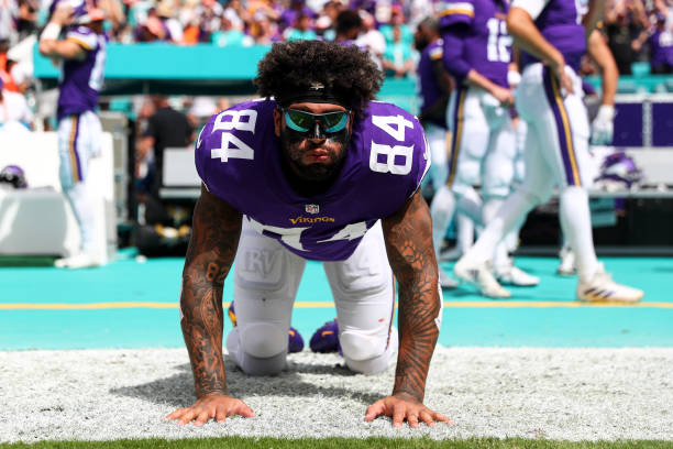 Irv Smith Jr. #84 of the Minnesota Vikings stretches on the sidelines prior to an NFL football game against the Miami Dolphins at Hard Rock Stadium...