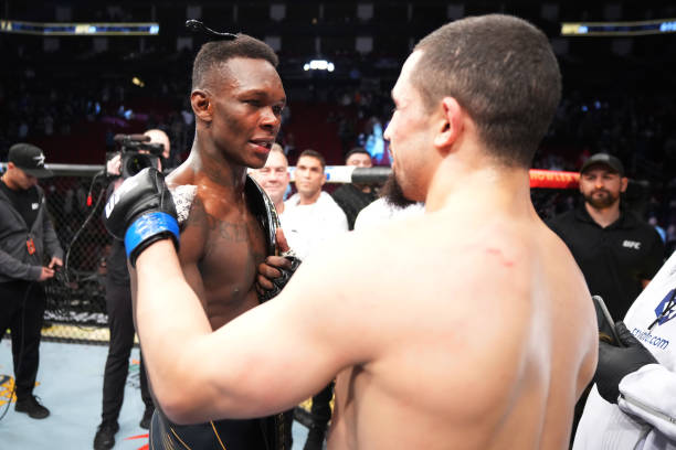 Israel Adesanya of Nigeria and Robert Whittaker of Australia embrace after Adesanya defeated Whittaker by unanimous decision in their UFC...