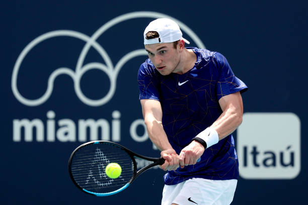 Jack Draper of Great Britain returns a shot to Gilles Simon of France during the Miami Open at Hard Rock Stadium on March 23, 2022 in Miami Gardens,...