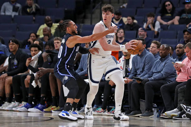 Jake LaRavia of the Memphis Grizzlies handles the ball against Devin Cannady of the Orlando Magic during a preseason game at FedExForum on October...