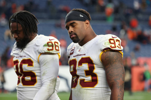 James Smith-Williams and Jonathan Allen of the Washington Football Team walk off the field after the Denver Broncos beat the Washington Football Team...