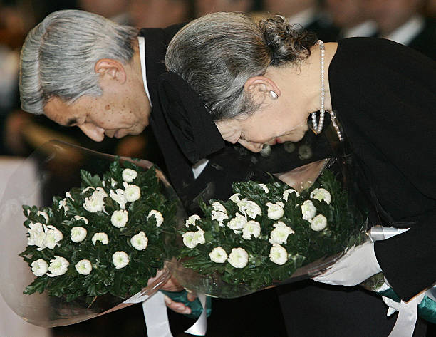japanese-emperor-akihito-and-empress-michiko-bow-as-they-offer-for-picture-id52003499