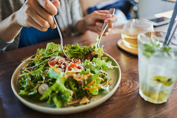 japanese woman eating a vegan lunch at a vegan cafe - dieta - fotografias e filmes do acervo