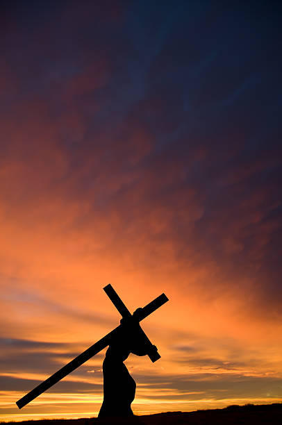 jesus carrying the cross with orange sunset ... vertical - good friday stockfoto's en -beelden