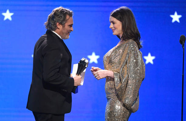 Joaquin Phoenix accepts the Best Actor award for 'Joker' from Anne Hathaway onstage during the 25th Annual Critics' Choice Awards at Barker Hangar on...