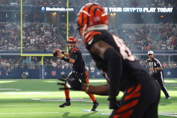 Joe Burrow of the Cincinnati Bengals passes the ball to Tee Higgins for a touchdown against the Dallas Cowboys during the fourth quarter at AT&T...