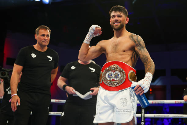 Joe Cordina celebrates victory with their trainer Tony Sims and the IBF World Super Featherweight belt after the IBF World Super Featherweight Title...