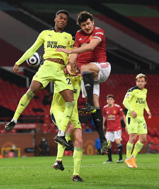 Joe Willock of Newcastle challenges Harry Maguire of Manchester United to the ball during the Premier League match between Manchester United and...