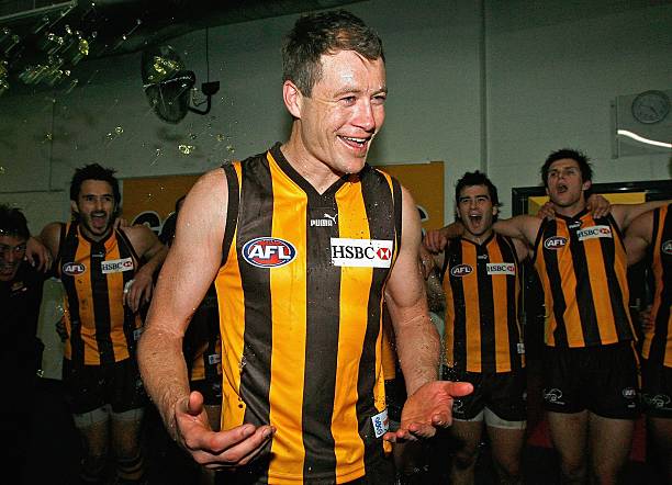 John Barker of the Hawks sing the club song in the centre of circle after winning the round 22 AFL match between the Hawthorn Hawks and the Geelong...
