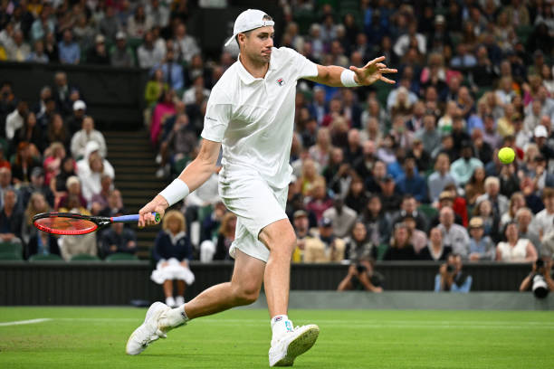 John Isner returns the ball to Britain's Andy Murray during their men's singles tennis match on the third day of the 2022 Wimbledon Championships at...