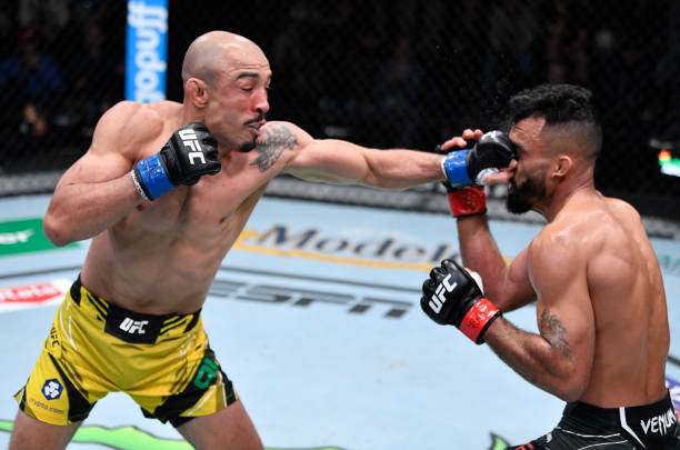 Jose Aldo of Brazil punches Rob Font in their bantamweight fight during the UFC Fight Night event at UFC APEX on December 04, 2021 in Las Vegas,...
