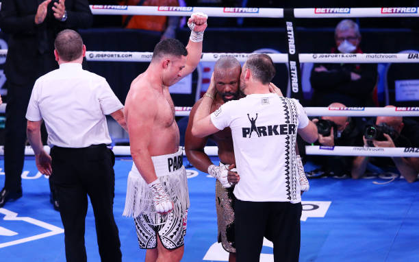 Joseph Parker celebrates victory as his trainer Andy Lee speaks to Derek Chisora after the WBO Intercontinental Heavyweight Title fight between...